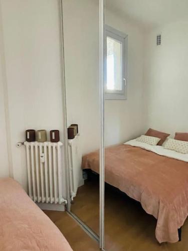 - une chambre avec un miroir à côté d'un lit dans l'établissement Cosy appartement la Promenade des Anglais, à Nice
