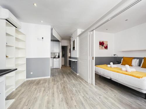 a bedroom with a large bed and a kitchen at Stay U-nique Apartments GranDeGracia in Barcelona