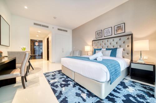 a bedroom with a large bed and a desk and a chair at Lively Studio at DAMAC Celestia A Dubai South by Deluxe Holiday Homes in Dubai