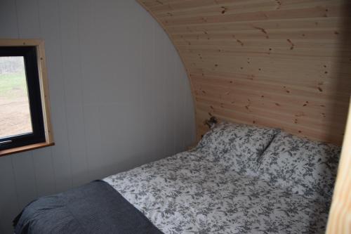 a bed in a small room with a window at Oakwood Luxury Glamping 