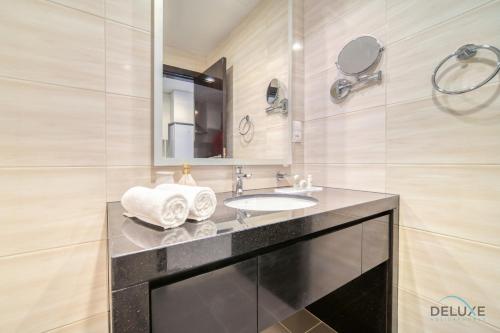a bathroom with a sink and a mirror at Lively Studio at DAMAC Celestia A Dubai South by Deluxe Holiday Homes in Dubai
