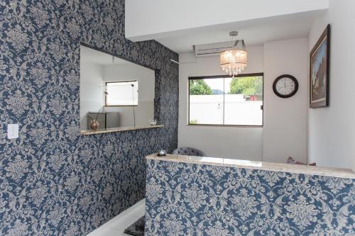 a bathroom with blue and white wallpaper and a mirror at Domum Hotel in Pindamonhangaba