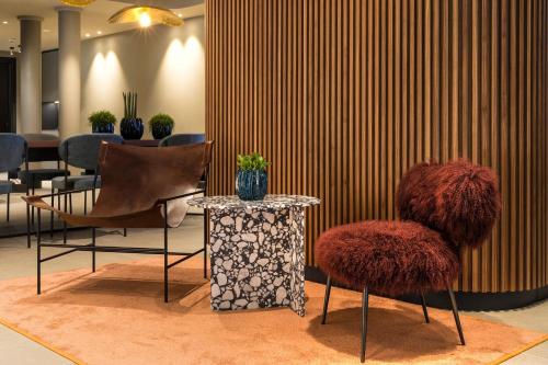 a lobby with two chairs and a table with a table sidx sidx at LUGANODANTE Boutique & Lifestyle Hotel in Lugano