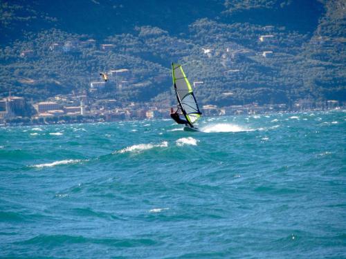 a person windsurfing in the ocean on the water at Relais Rosa Dei Venti -Ciao Vacanze- in Moniga