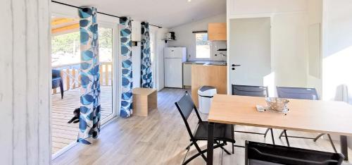 a kitchen and dining room with a table and chairs at Camping Kévano Plage in Pianottoli-Caldarello