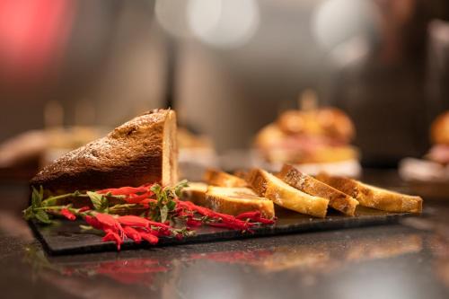 a plate with a sandwich and bread on a table at LUGANODANTE Boutique & Lifestyle Hotel in Lugano