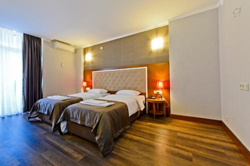 a hotel room with two beds and a window at Hotel 19 Batumi in Batumi