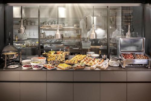 a kitchen with many different types of food on a counter at LUGANODANTE Boutique & Lifestyle Hotel in Lugano
