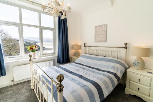 a bedroom with a bed and a large window at Tegfryn (Sleeps 8), 5*, Sea View, Borth y Gest in Porthmadog
