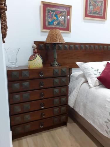 a dresser with a lamp on it next to a bed at Estudio Vandelvira in Baeza