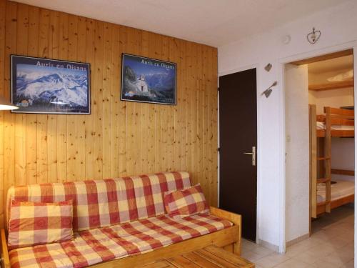 - un salon avec un canapé et deux photos sur le mur dans l'établissement Studio cosy 3 couchages, balcon sud, skis aux pieds, commerces à proximité - Auris en Oisans - FR-1-297-74, à Auris