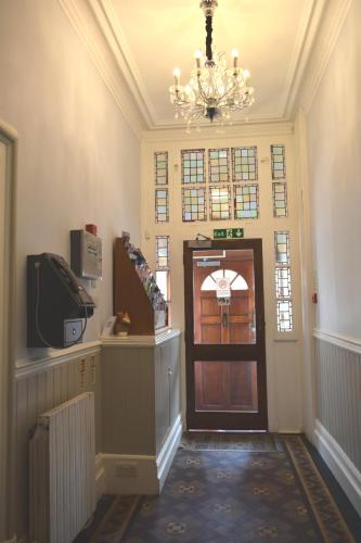 a hallway with a chandelier and a door in a building at Charlie Hotel in London