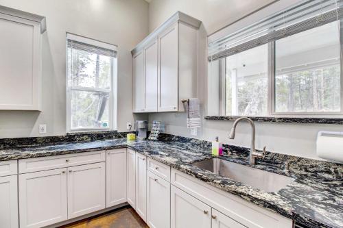 a kitchen with white cabinets and a sink at Pinetop-Lakeside Home with Private Hot Tub and Bar in Lake of the Woods