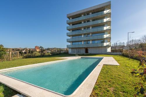 une piscine en face d'un bâtiment dans l'établissement Luxurious Impressive Apartment - Balcony and Pool, à Vila Nova de Gaia