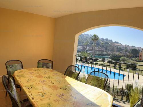 - une salle à manger avec une table et une vue sur la piscine dans l'établissement Location 3 chambres avec piscine, tennis et garage - Clim, Terrasse et Proche Plage - FR-1-100-279, à Cavalaire-sur-Mer