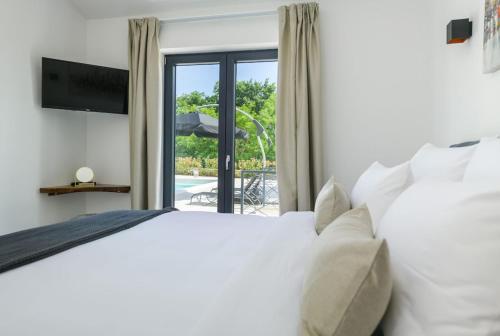 a bedroom with a bed and a sliding glass door at Villa Vetosa by IstriaLux in Žminj