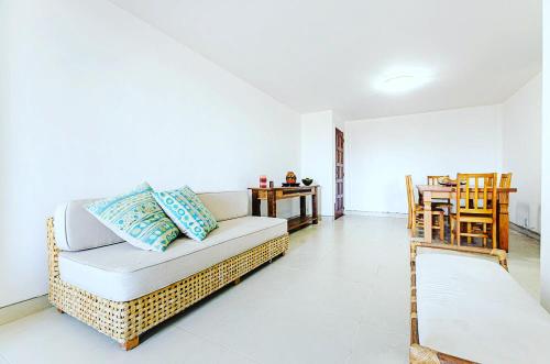 ein Wohnzimmer mit einem Sofa und einem Tisch in der Unterkunft Excelente apartamento no melhor point de Itaúna a 150 m da praia in Saquarema