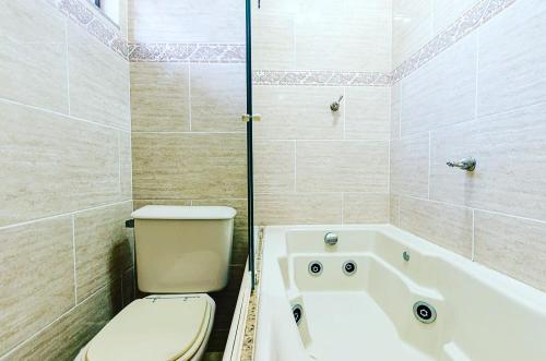 a bathroom with a toilet and a bath tub at Excelente apartamento no melhor point de Itaúna a 100 m da praia in Saquarema