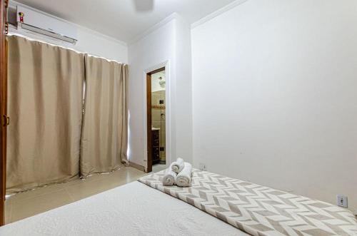 a white room with a bed and a window at Excelente apartamento no melhor point de Itaúna a 100 m da praia in Saquarema