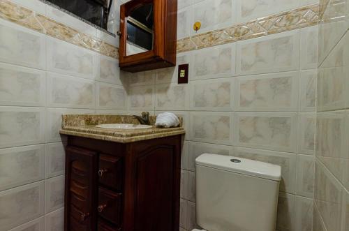 a bathroom with a toilet and a sink and a mirror at Excelente apartamento no melhor point de Itaúna a 100 m da praia in Saquarema