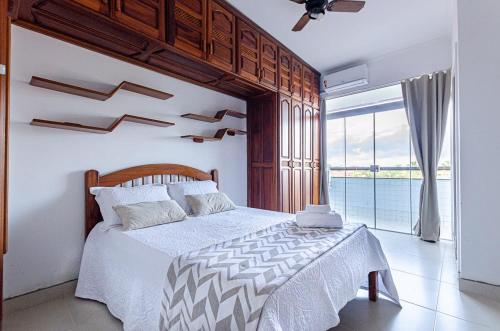 ein Schlafzimmer mit einem großen Bett und einem großen Fenster in der Unterkunft Excelente apartamento no melhor point de Itaúna a 150 m da praia in Saquarema