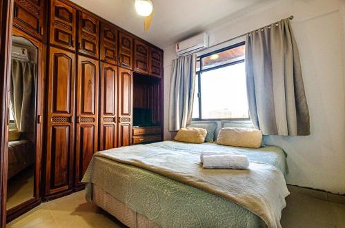 a bedroom with a large bed and a window at Excelente apartamento no melhor point de Itaúna a 100 m da praia in Saquarema