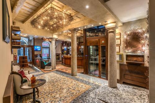 a lobby with columns and a table and chairs at Hotel Santa Marta Suites in Milan