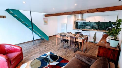 uma cozinha e sala de estar com mesa e cadeiras em Charmant gîte à la ferme em Herbignac