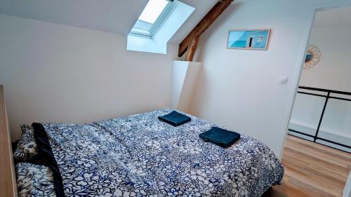 um quarto com uma cama com um edredão azul e branco em Charmant gîte à la ferme em Herbignac