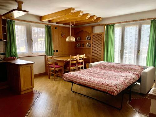 a bedroom with a bed and a table and chairs at Villa Iris Asiago - giardino e parcheggio in Asiago