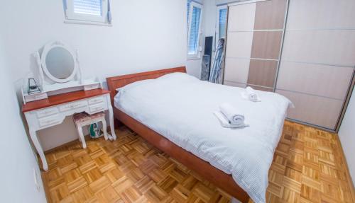 um quarto com uma cama, um toucador e um espelho. em Apartment Focus em Mostar