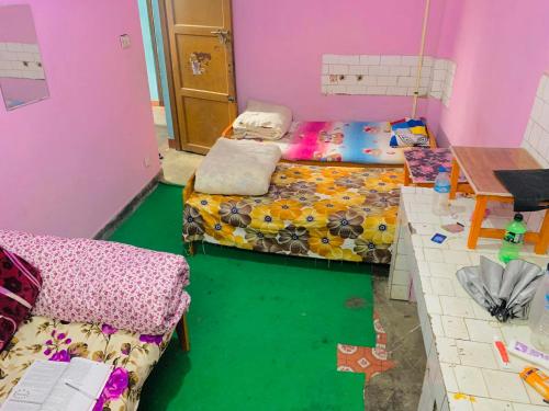 Cette chambre dispose de 2 lits et d'un sol vert. dans l'établissement Biju Girls Hostel for females only, à Katmandou