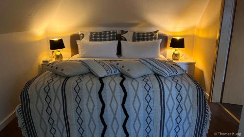 a bedroom with a bed with pillows and two lamps at Kungs Ferienwohnung in Cottbus