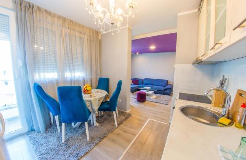 uma cozinha e sala de jantar com uma mesa e cadeiras azuis em Apartment Focus em Mostar