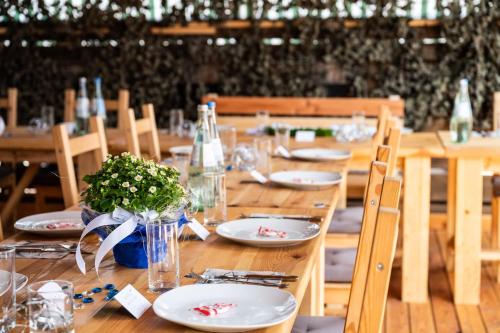 una larga mesa de madera con platos y flores. en 1852 Landgasthof, en Elze