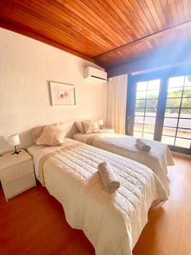 a bedroom with two beds and a window at Vila Alice in Quarteira