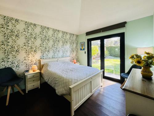 a bedroom with a bed and a desk and a window at Villa Serena in Santa Cristina d'Aro