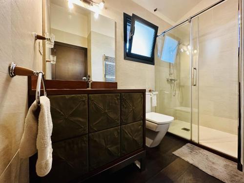 a bathroom with a glass shower and a toilet at Villa Serena in Santa Cristina d'Aro