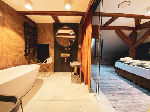 a bathroom with a tub and a sink at Ostoja Chobienice in Chobienice