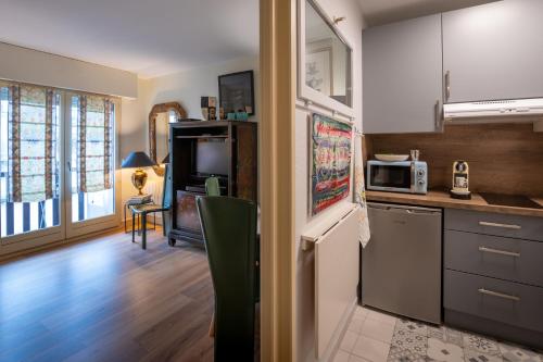 a kitchen with a refrigerator and a microwave at Appartement deauville place Morny non fumeur in Deauville