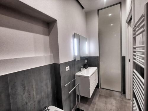 uma casa de banho com um lavatório branco e um espelho. em Rooms Corso Porta Nuova em Verona