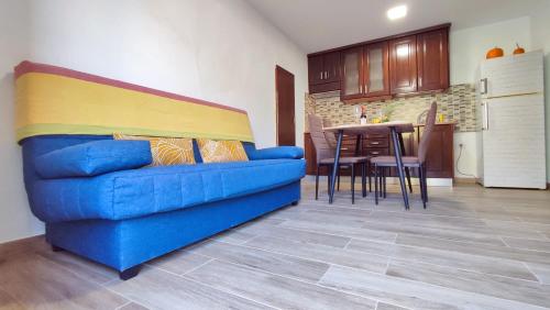 um sofá azul numa sala de estar com uma cozinha em Anmar Tasarte em Playa de Tasarte