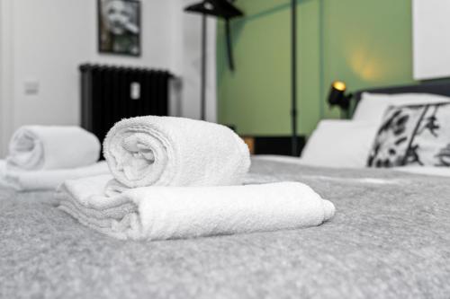 uma pilha de toalhas sentadas em cima de uma cama em APARTVIEW Apartments Krefeld - WLAN - Zentral - ruhig em Krefeld