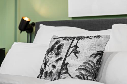 a bed with a pillow with a picture of a man on a palm tree at APARTVIEW Apartments Krefeld - WLAN - Zentral - ruhig in Krefeld