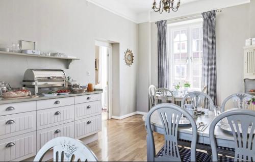 a kitchen and dining room with a table and chairs at Köpmansgården Bed & Breakfast in Vellinge