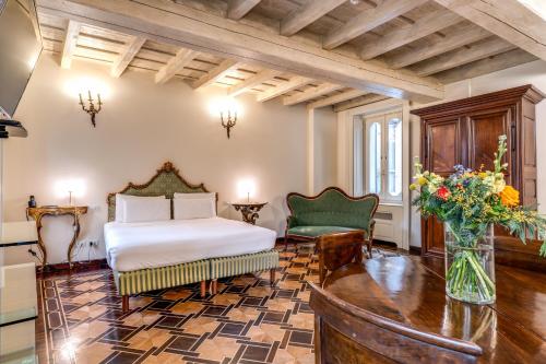 a bedroom with a bed and a vase of flowers at Hotel Santa Marta Suites in Milan