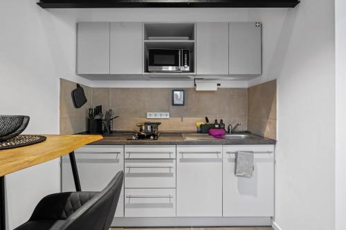 a kitchen with white cabinets and a counter top at APARTVIEW Apartments Krefeld - WLAN - Zentral - ruhig in Krefeld