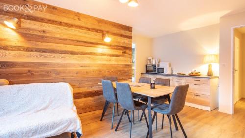 Cette chambre est dotée d'un mur en bois avec une table et des chaises. dans l'établissement La Pirouette - Appt pour 8 vue sur piste, à Villarembert