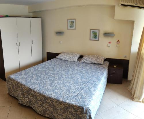 a bedroom with a bed with a blue comforter at NikeaPark in Golden Sands