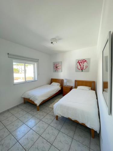 a bedroom with two beds and a window at LINHA D ÁGUA - ap in Salema